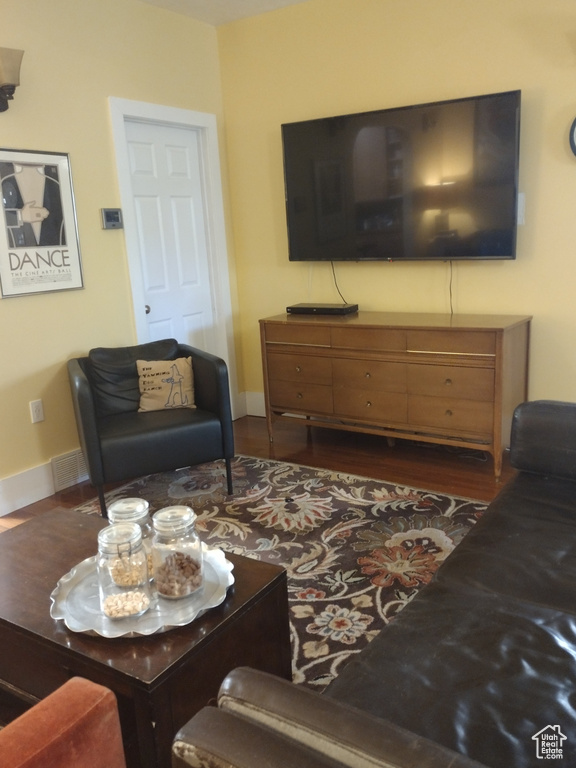 Living room with visible vents, baseboards, and dark wood finished floors