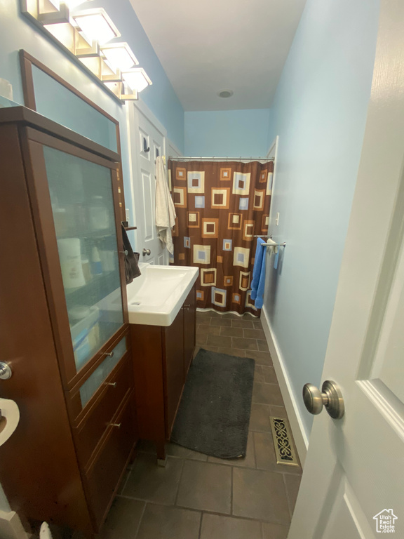 Bathroom with tile patterned flooring, visible vents, baseboards, a shower with curtain, and vanity