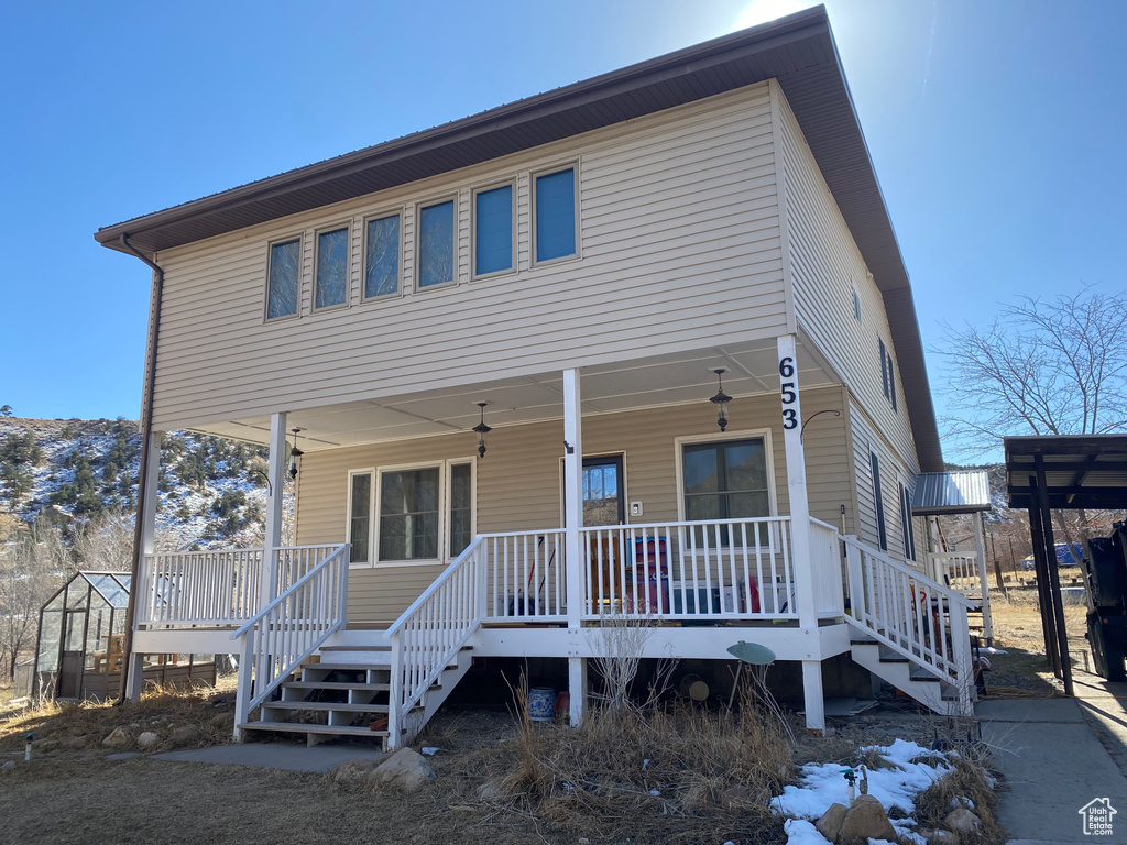 View of front facade with stairway and covered porch