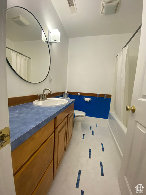 Bathroom with tile patterned floors, visible vents, toilet, and vanity