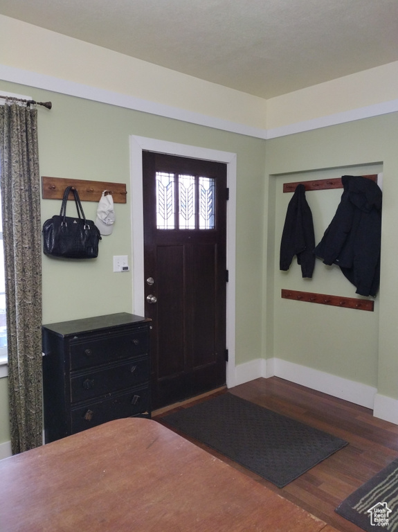 Entryway featuring baseboards and wood finished floors