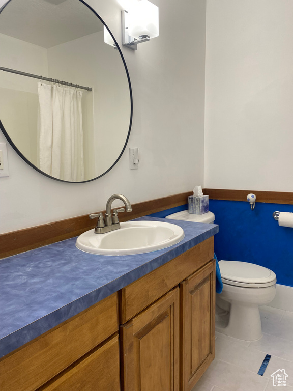 Bathroom with tile patterned flooring, toilet, vanity, and a shower with curtain