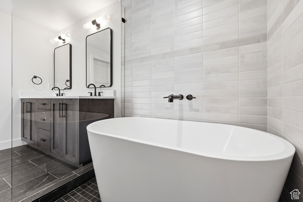 Freestanding soaking tub with a wall-mounted faucet, complemented by a tiled accent wall