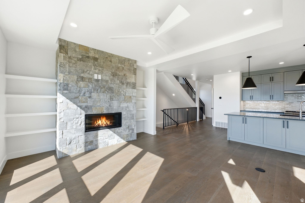 Stone-clad fireplace with a linear firebox, flanked by built-in shelving