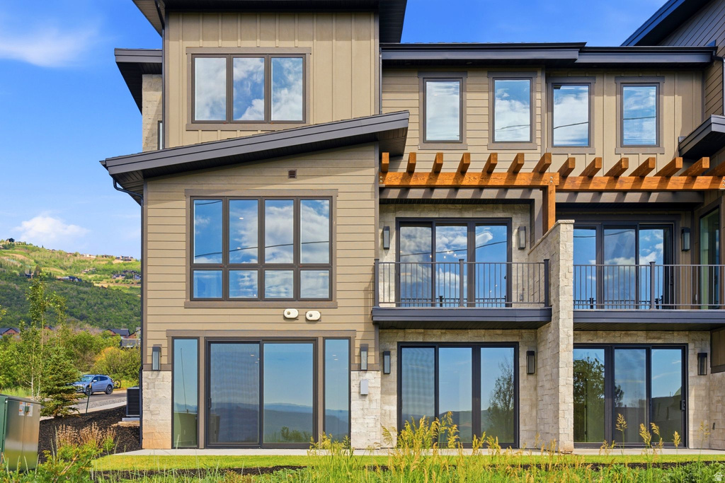 Contemporary multi-level exterior with tan siding and stone veneer accents