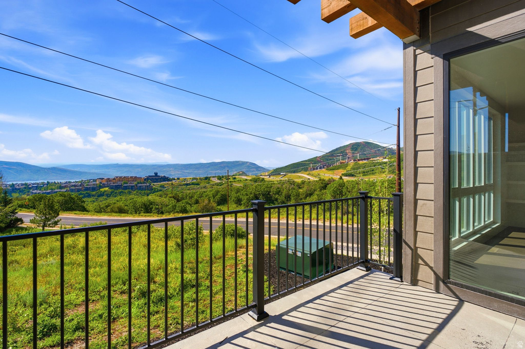 Outdoor patio featuring concrete flooring, a black metal railing, and a sliding glass door