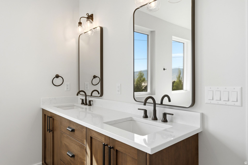 Double vanity with wood-finish cabinetry, white countertops, and integrated sinks