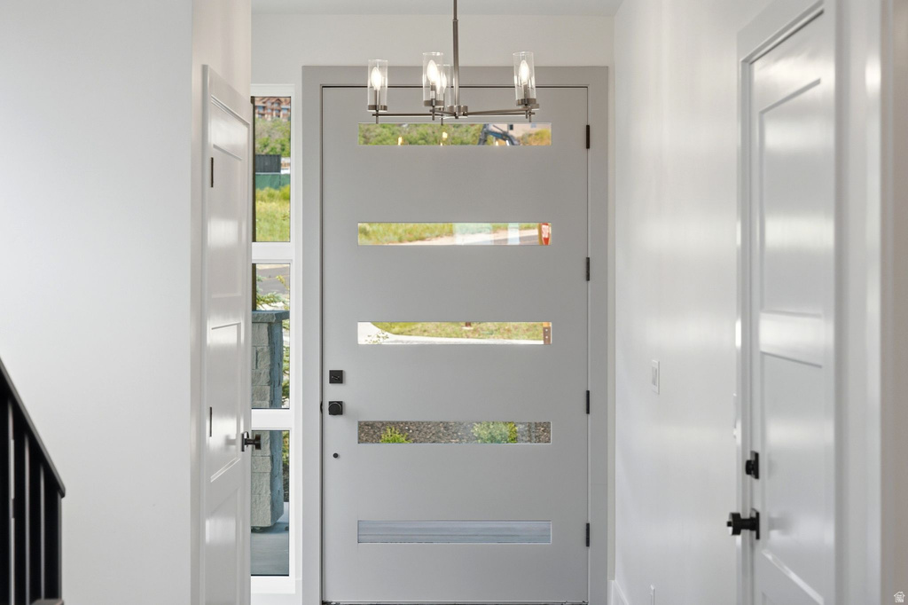 Modern entry door with horizontal glass inserts, flanked by a full-height sidelight and white interior doors