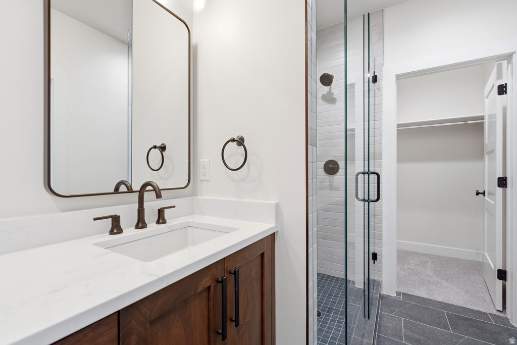 Bathroom featuring a wood-finish vanity with a white countertop and integrated sink, bronze-finish faucet, and a rectangular mirror with a bronze-finish frame