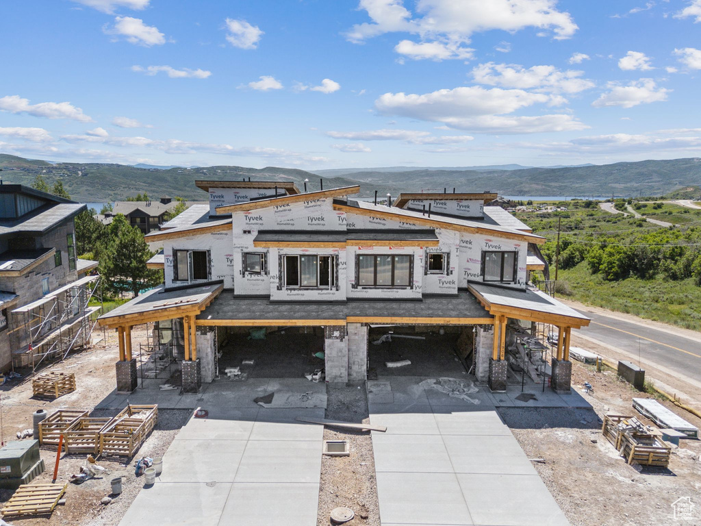 View of front of property with a mountain view, concrete driveway, and a patio area