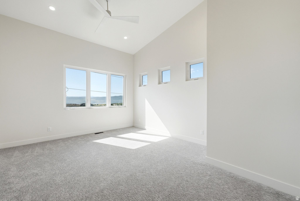 Bright interior space featuring a vaulted ceiling with recessed lighting and a ceiling fan