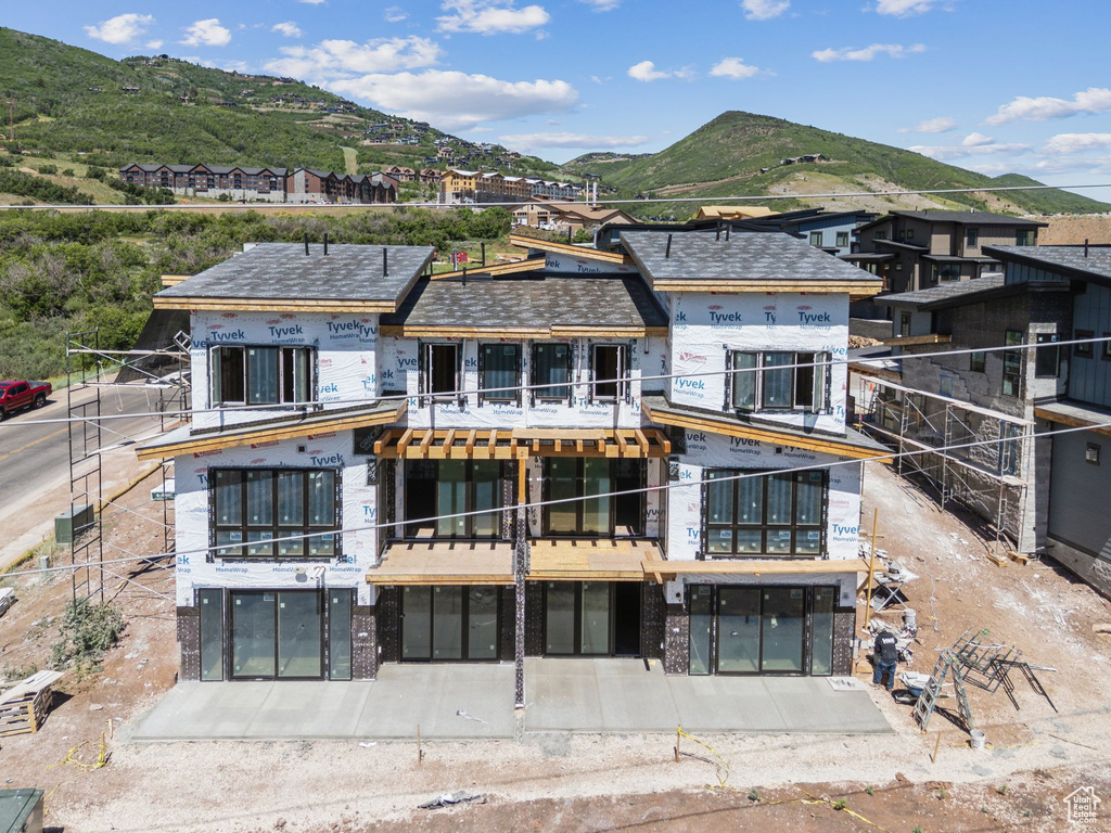 Rear view of property featuring a mountain view and a balcony