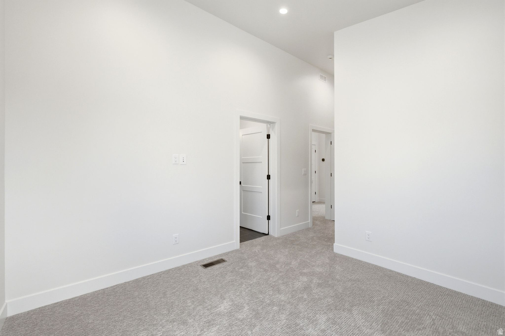 Spacious room with light gray carpeting and white baseboards