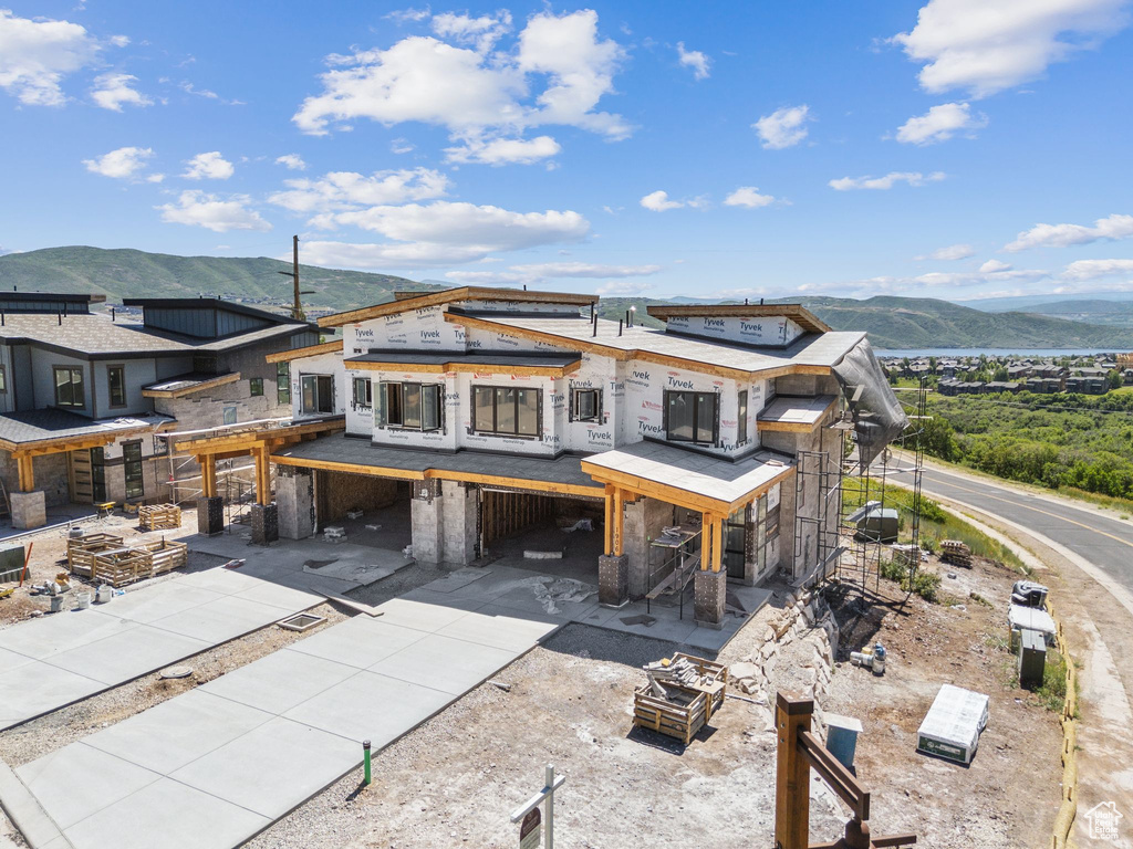 View of front of house with a carport, a mountain view, and concrete driveway