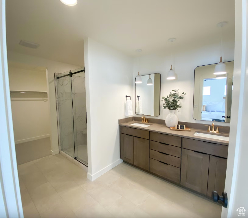 Bathroom featuring a sink, a marble finish shower, ensuite bath, and double vanity