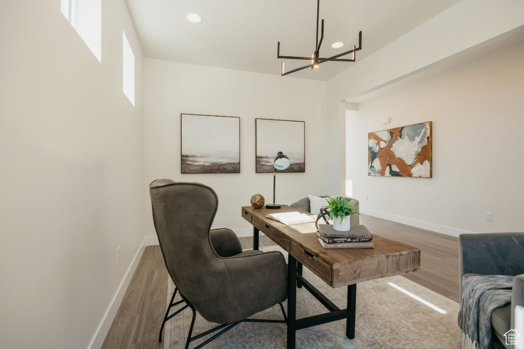 Office space featuring a chandelier, recessed lighting, baseboards, and wood finished floors