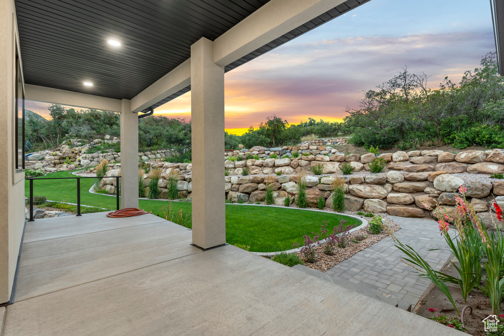 Patio terrace at dusk with a yard