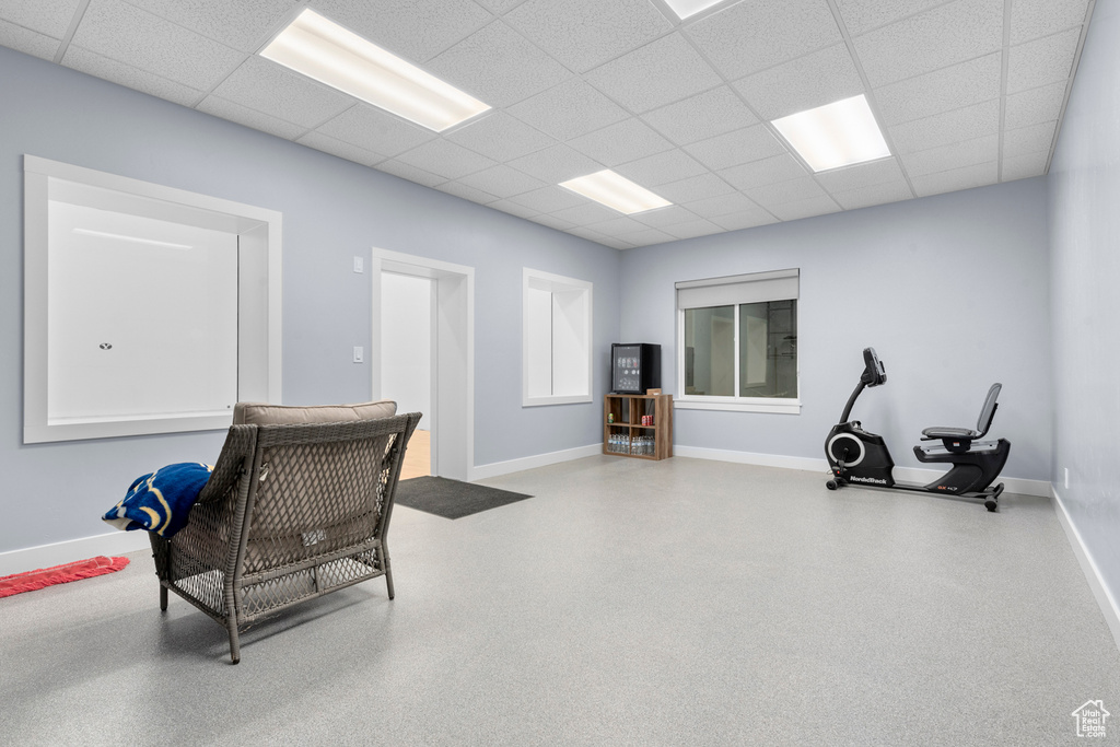 Misc room featuring speckled floor, a paneled ceiling, and baseboards