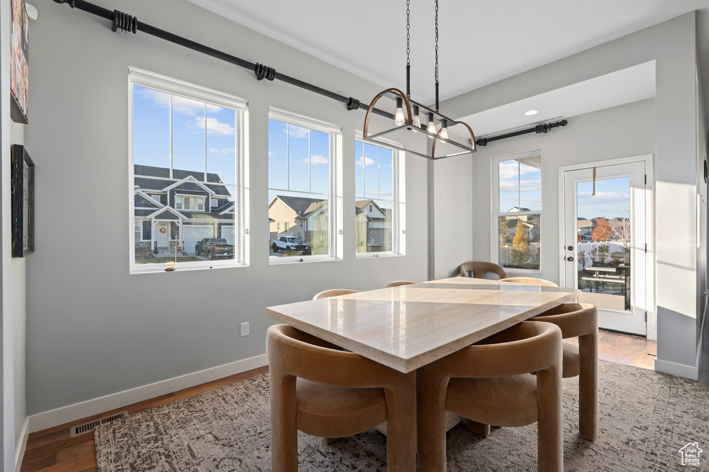 Dining room with plenty of natural light, visible vents, light wood-style floors, and baseboards