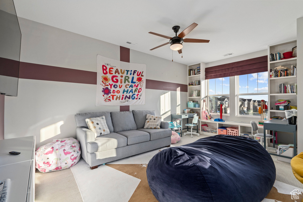 Carpeted living room with visible vents and ceiling fan