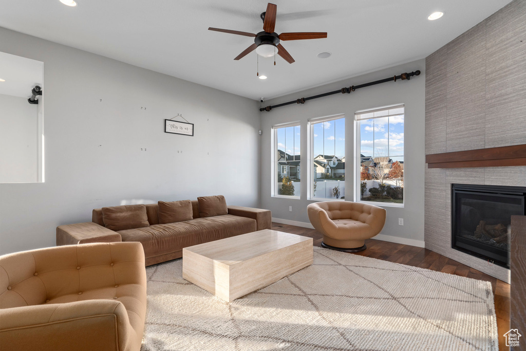Living room with a ceiling fan, wood finished floors, recessed lighting, a fireplace, and baseboards