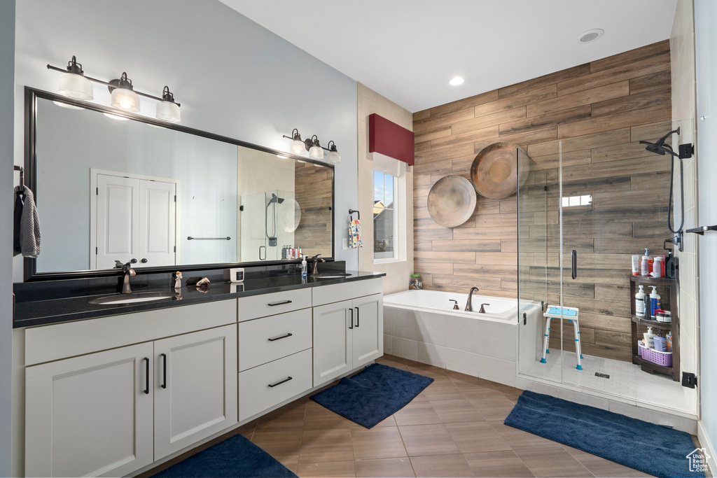 Full bathroom with a sink, double vanity, a bath, and a shower stall