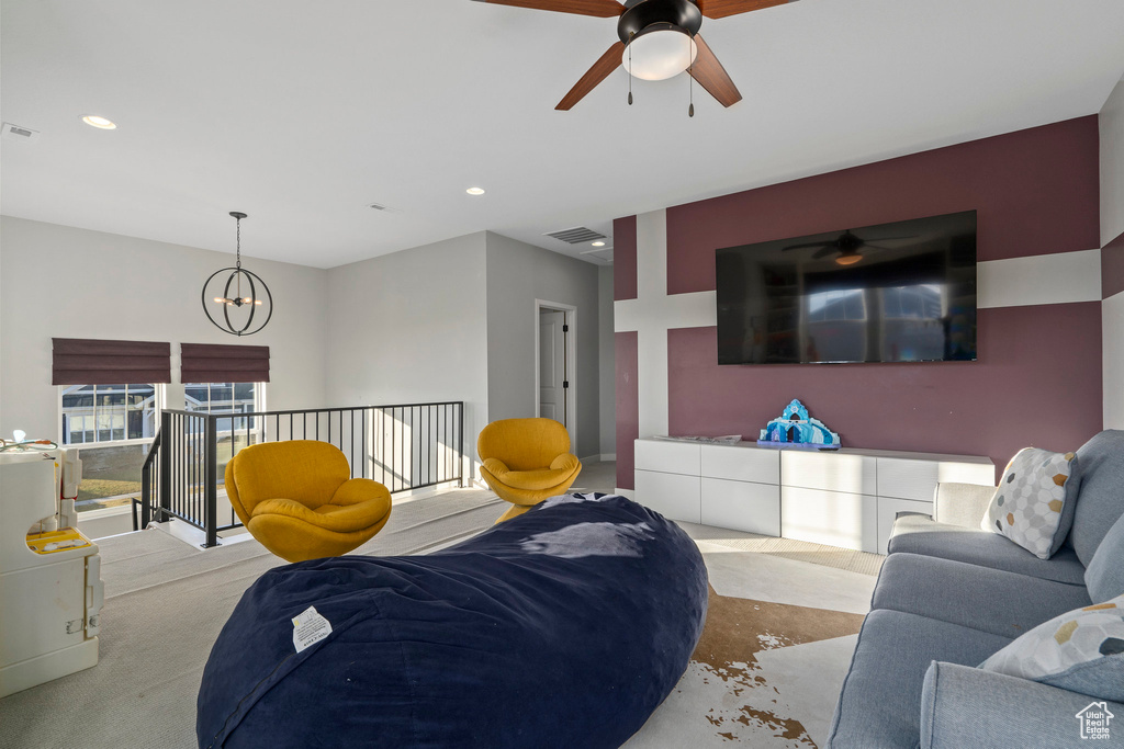 Carpeted living area with a chandelier, visible vents, and recessed lighting