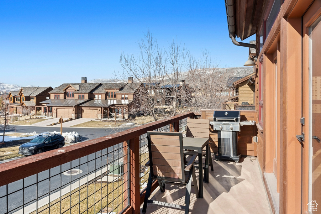 Balcony with grilling area, a residential view, and a mountain view