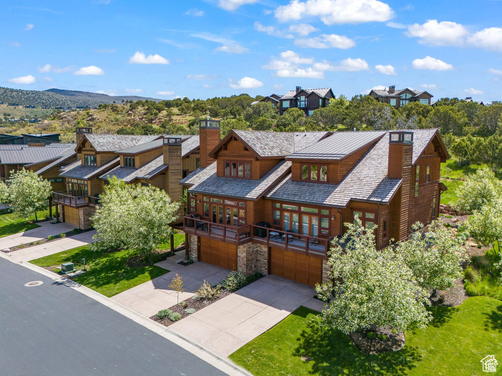 View of front of property featuring a chimney, a garage, french doors, and stone siding