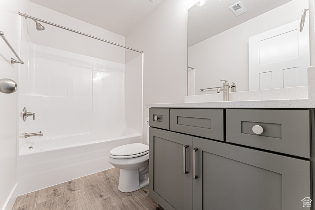 Bathroom with vanity, wood finished floors, and shower / bathtub combination