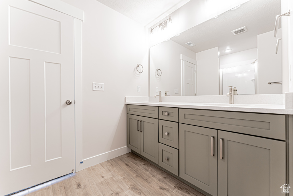 Bathroom with double vanity and wood finished floors