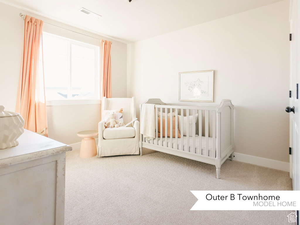 Carpeted bedroom with visible vents, baseboards, and a nursery area