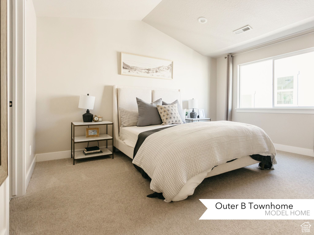 Bedroom featuring visible vents, light carpet, baseboards, and vaulted ceiling