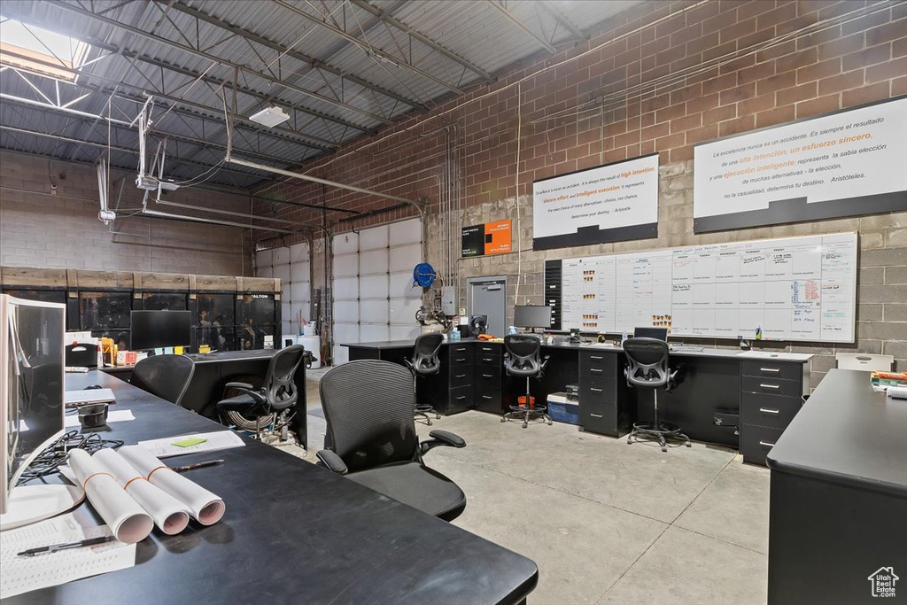 Office space featuring a towering ceiling, concrete flooring, and a workshop area