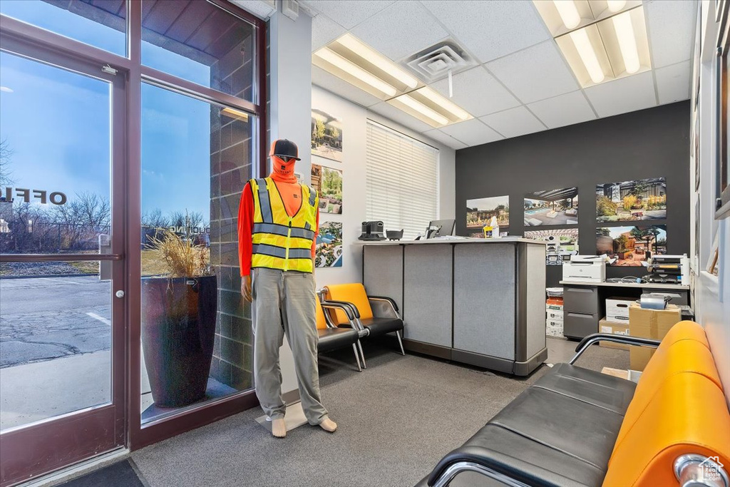 Interior space featuring a paneled ceiling, carpet, and visible vents
