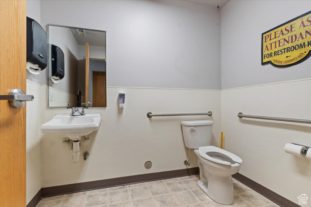 Half bathroom featuring wainscoting and toilet