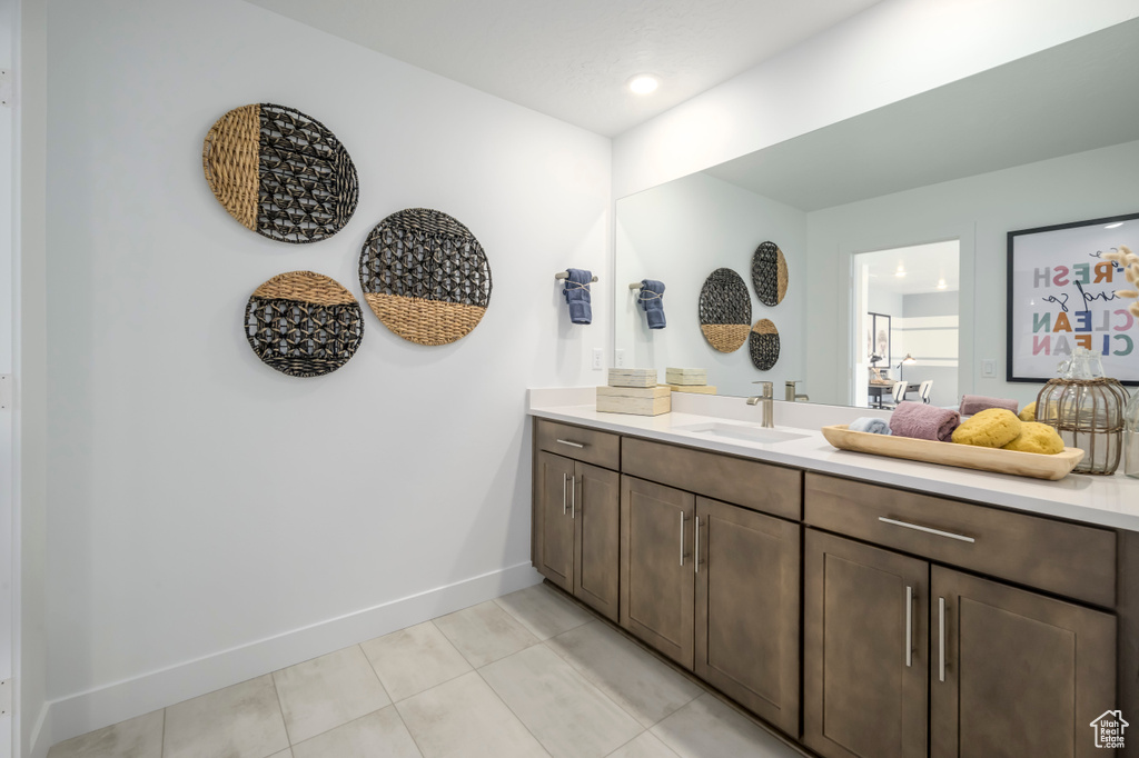 Bathroom featuring vanity, baseboards, and tile patterned flooring