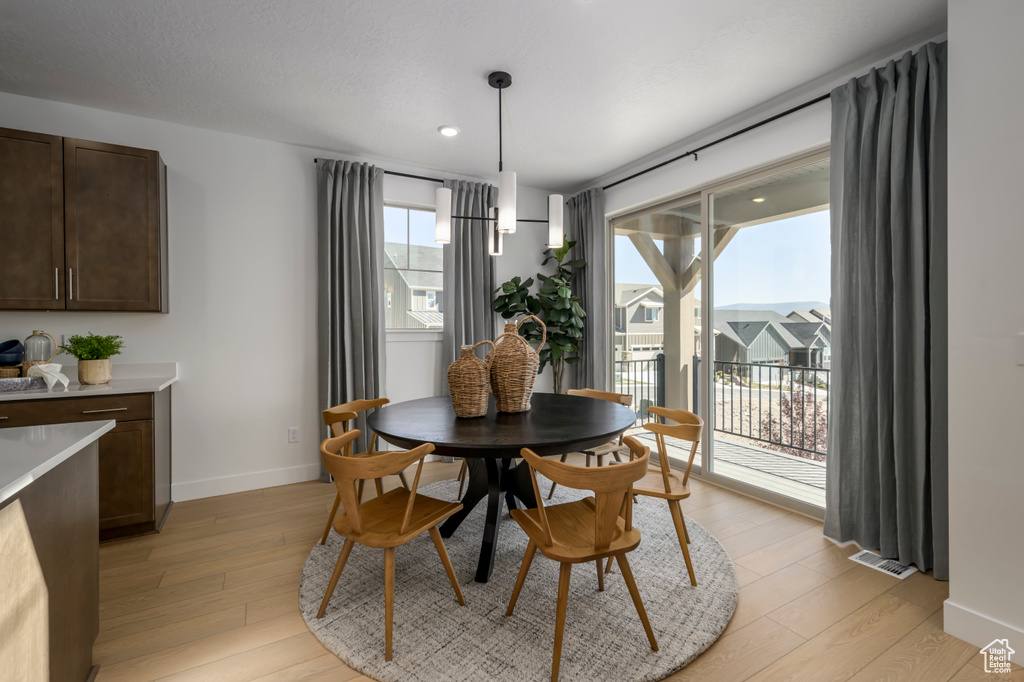 Dining room featuring visible vents, light wood-type flooring, and baseboards