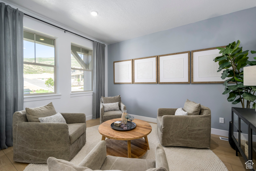 Sitting room with visible vents, baseboards, and light wood finished floors