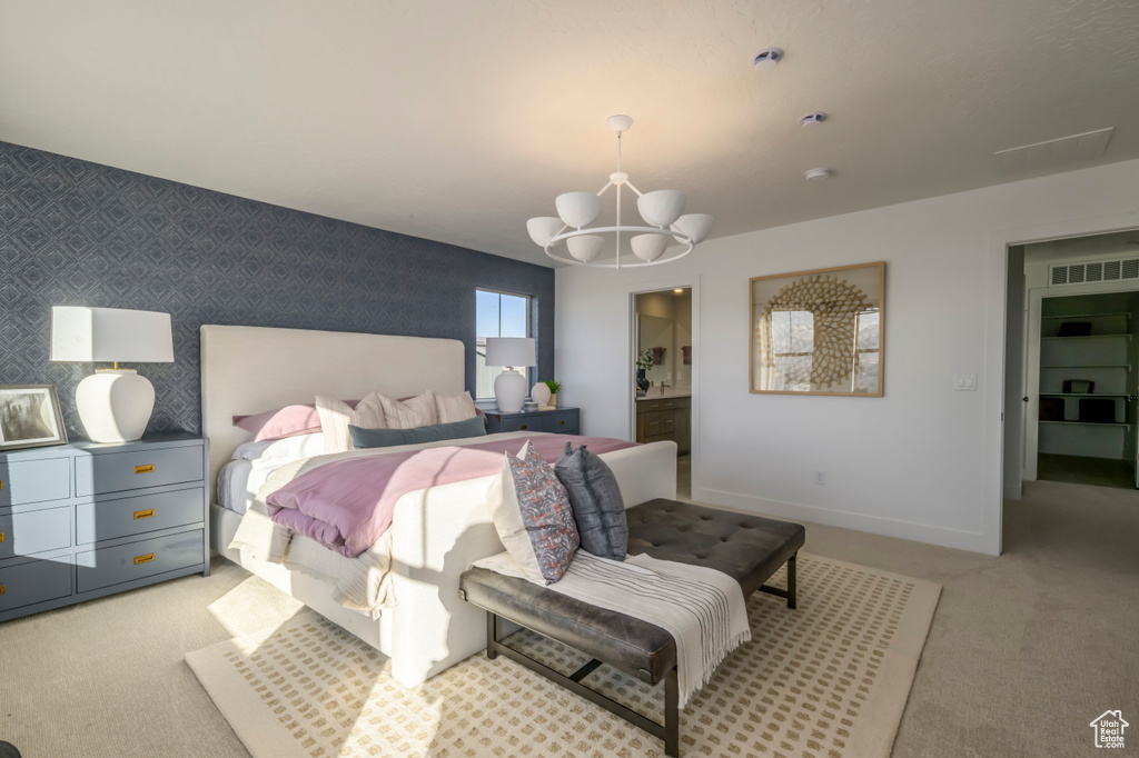 Carpeted bedroom featuring visible vents, wallpapered walls, baseboards, a chandelier, and an accent wall