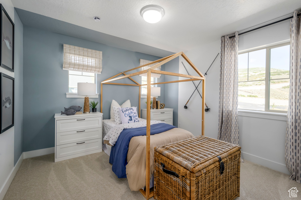 Bedroom with light colored carpet and baseboards