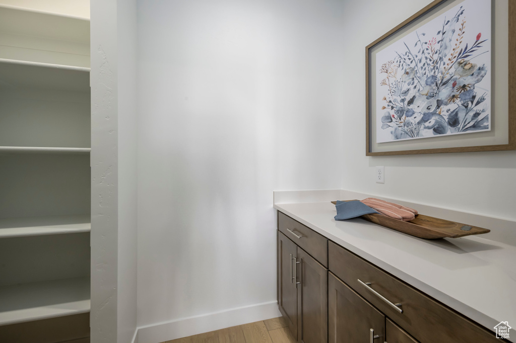 Bathroom featuring vanity, baseboards, and wood finished floors