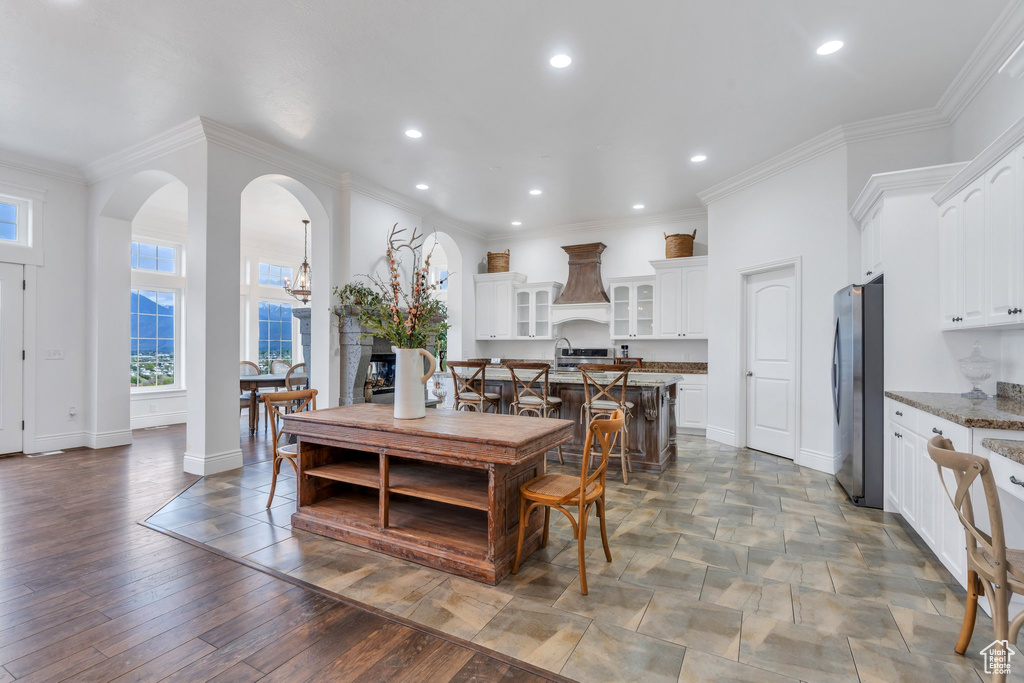 Dining area with crown molding, arched walkways, baseboards, and recessed lighting