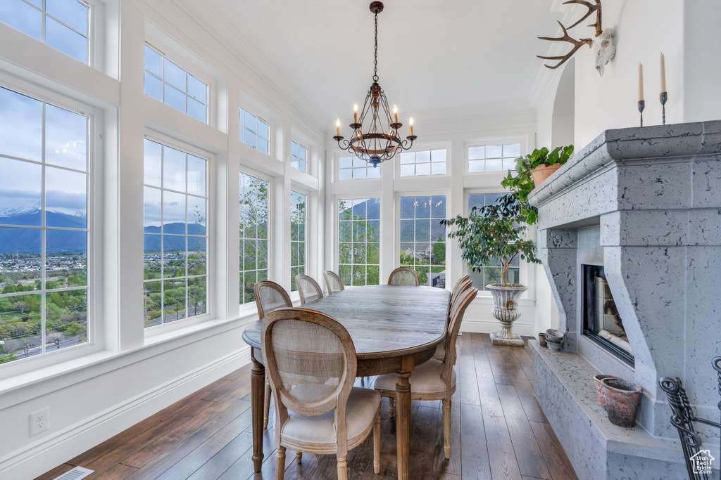 Sunroom featuring ornamental molding, wood-type flooring, a mountain view, and a notable chandelier