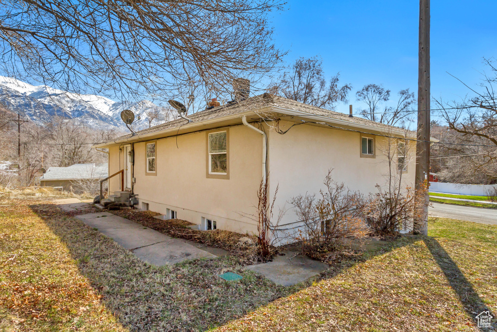 View of home\'s exterior featuring a mountain view, stucco siding, entry steps, and a chimney
