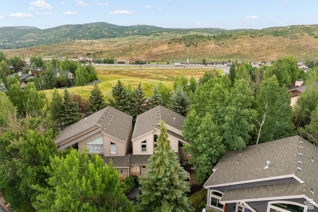 Aerial view of property and surrounding area with a mountain backdrop