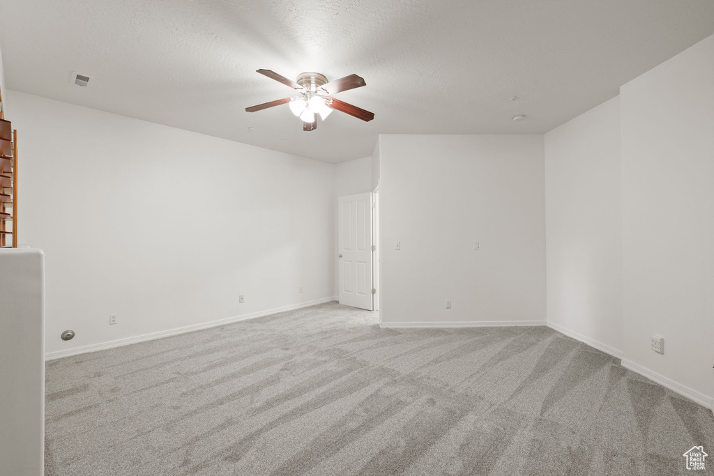 Spare room featuring a ceiling fan and carpet