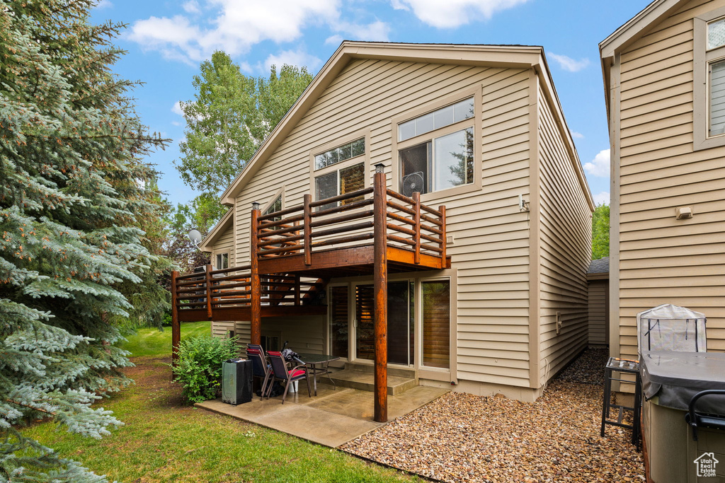 Back of property with a deck and a patio area