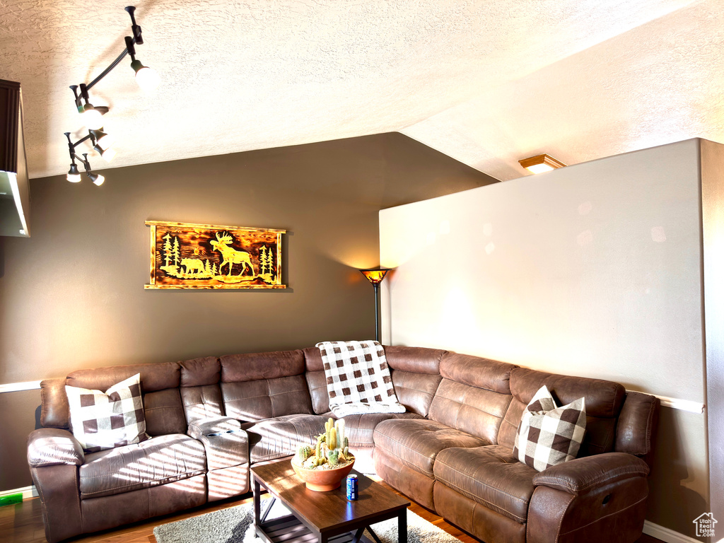 Living room featuring a textured ceiling and vaulted ceiling