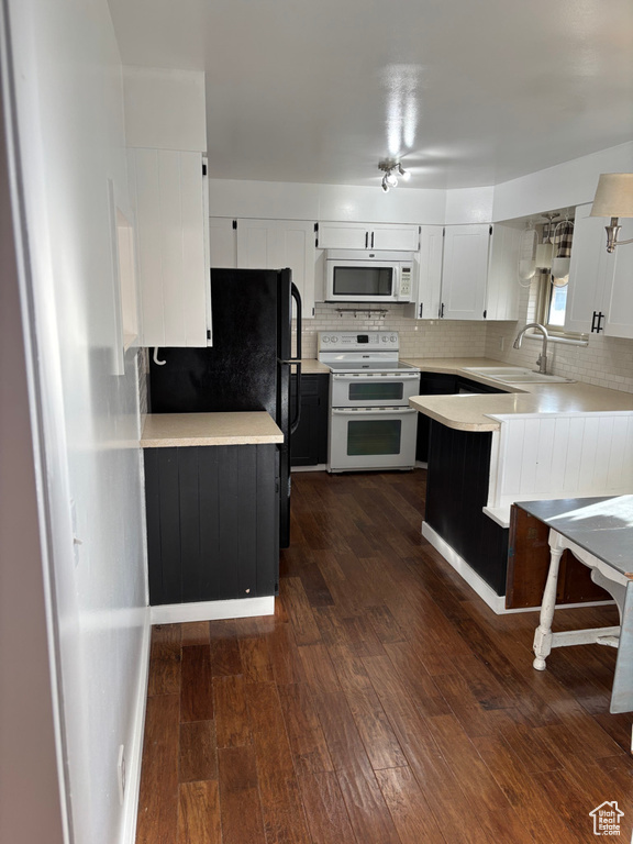 Kitchen featuring a sink, double oven range, white microwave, and dark wood finished floors
